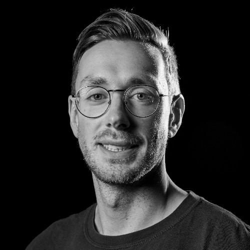 A black and white photo of a man smiling.